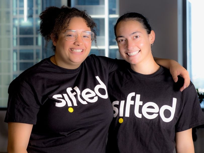 Two Sifted employees pose for a photo while wearing company-branded T-shirts